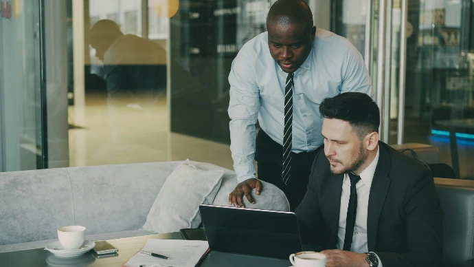 Two businessmen collaborating over a laptop